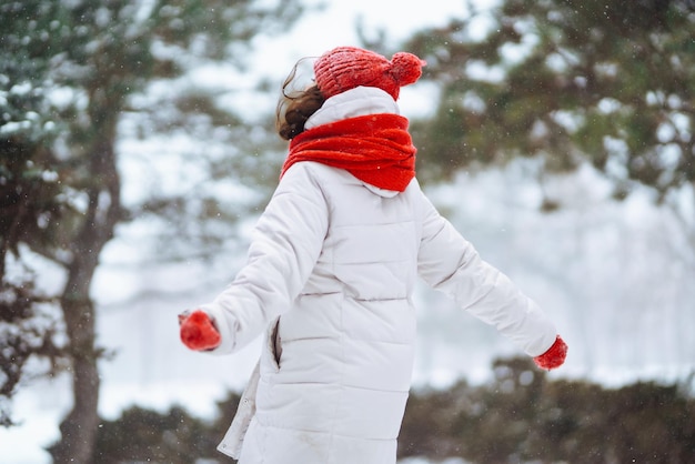 Jeune femme en vêtements de style hiver sur fond de forêt enneigée Vacances nature