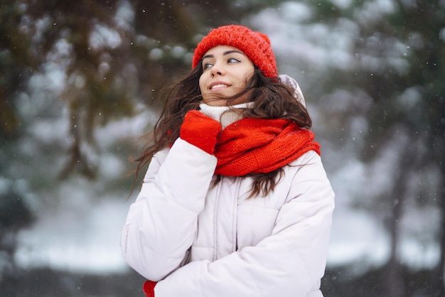 Jeune femme en vêtements de style hiver sur fond de forêt enneigée Vacances nature