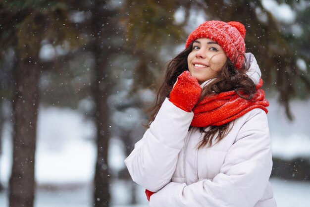 Jeune femme en vêtements de style hiver sur fond de forêt enneigée Vacances nature