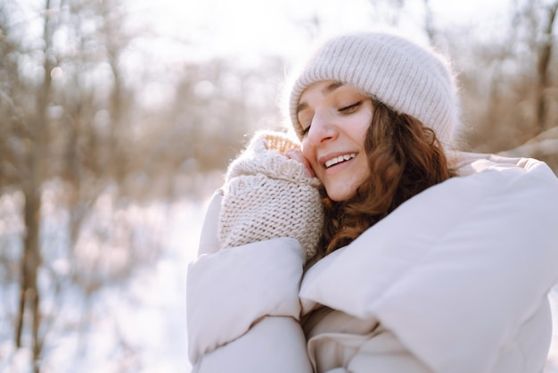 Jeune femme en vêtements de style hiver marchant dans le parc enneigé Vacances de mode d'hiver