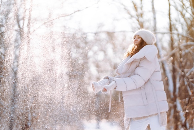 Jeune femme en vêtements de style hiver marchant dans le parc enneigé Vacances de mode d'hiver