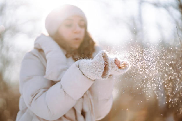 Jeune femme en vêtements de style hiver marchant dans le parc enneigé Vacances de mode d'hiver