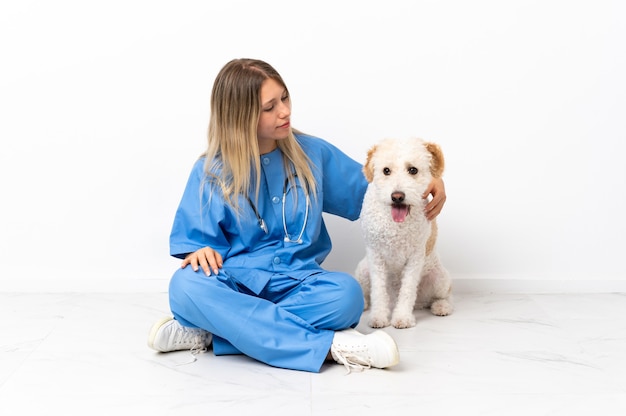 Jeune femme vétérinaire avec chien assis sur le sol