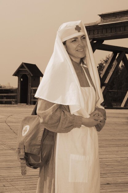 Photo une jeune femme vêtue d'un costume à l'ancienne détourne son regard alors qu'elle se tient à l'extérieur.