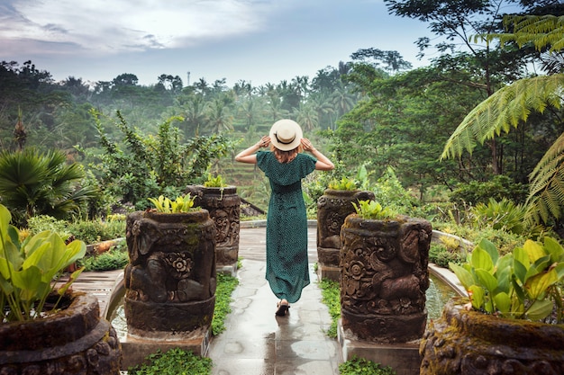 Photo une jeune femme vêtue d'une longue robe couleur émeraude et coiffée d'un chapeau