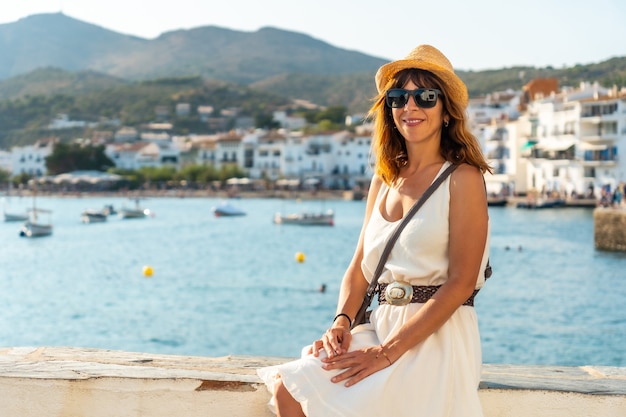 Une jeune femme vêtue d'une robe blanche à Cadaques au bord de la mer, Costa Brava de Catalogne, Gérone, mer Méditerranée. Espagne