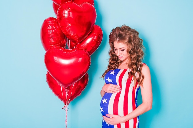 Jeune femme vêtue de vêtements patriotiques portant un drapeau américain