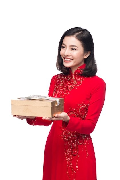 Jeune femme vietnamienne en robe Ao Dai tenant une boîte-cadeau.