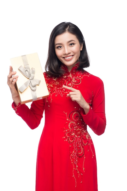 Jeune femme vietnamienne en robe Ao Dai tenant une boîte-cadeau.