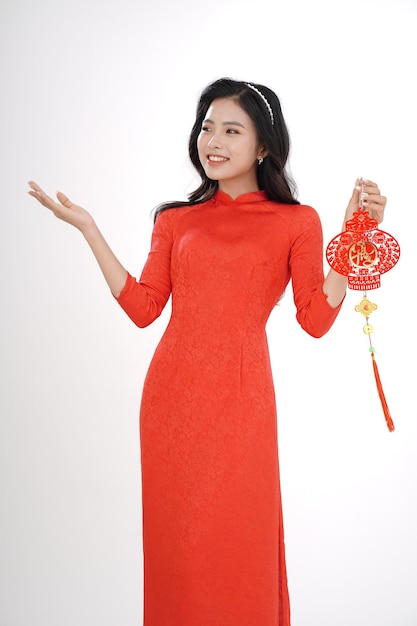 Jeune femme vietnamienne en robe traditionnelle pour la saison des festivals du Nouvel An lunaire, isolée sur fond blanc