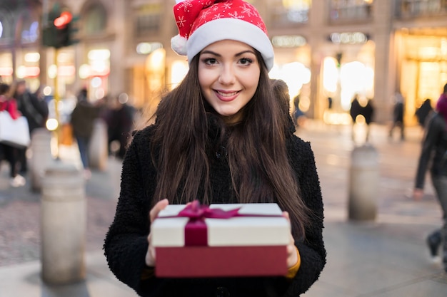 Jeune femme vous offrant un cadeau pour Noël