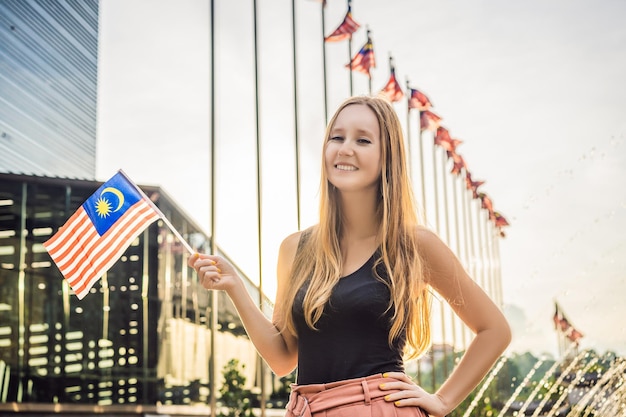 La jeune femme voyage en Malaisie tient le drapeau malaisien