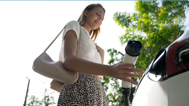 Photo une jeune femme voyage avec une voiture électrique dans les intérieurs d'une ville verte et durable