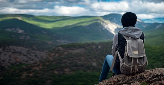 Jeune femme voyageant au sommet de la falaise de la montagne