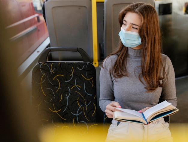 Photo jeune femme voyageant en bus de la ville en lisant un livre