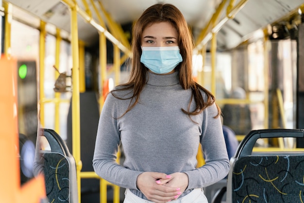 Photo jeune femme voyageant en bus de la ville avec masque chirurgical