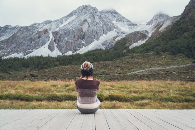 Jeune femme voyageur assis et regardant beau paysage et se sentir seul, concept de style de vie voyage