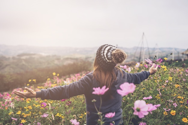 Photo jeune femme voyageur marchant dans le champ de la fleur