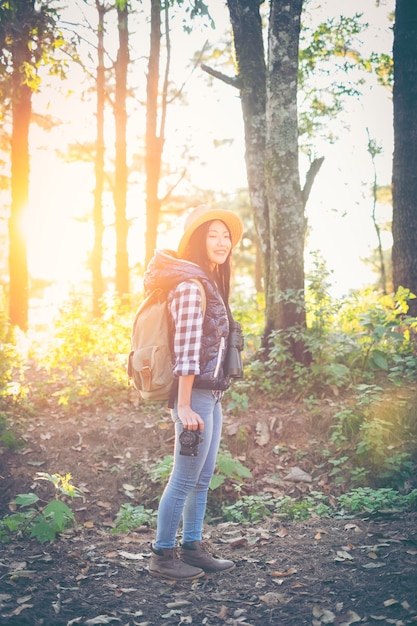 Jeune femme voyageur avec sac à dos dans un bois