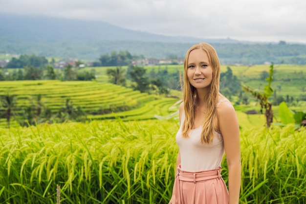 Jeune femme voyageuse sur les belles terrasses de riz de Jatiluwih sur fond de célèbres volcans de Bali, en Indonésie.