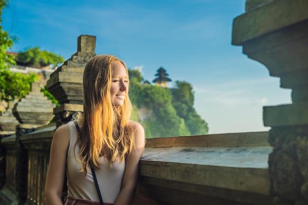 Jeune femme voyageuse dans le temple Pura Luhur Uluwatu, Bali, Indonésie. Paysage incroyable - falaise avec ciel bleu et mer.