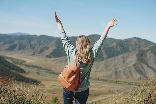 Jeune femme voyageuse dans des vêtements décontractés avec sac à dos de dos sur une belle vue sur les montagnes