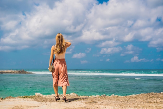 Jeune femme voyageuse sur l'étonnante plage de Melasti aux eaux turquoises, île de Bali Indonésie