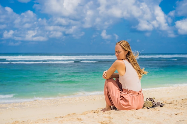 Jeune femme voyageuse sur l'étonnante plage de Melasti aux eaux turquoises, île de Bali Indonésie