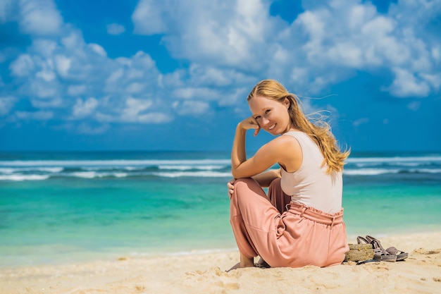 Jeune femme voyageuse sur l'étonnante plage de Melasti aux eaux turquoises, île de Bali Indonésie