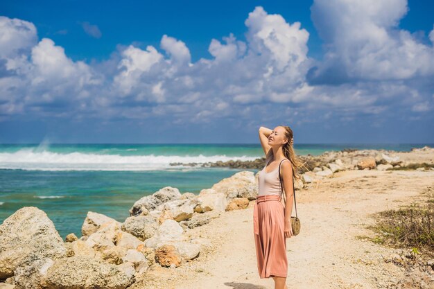Jeune femme voyageuse sur l'étonnante plage de Melasti aux eaux turquoises, île de Bali Indonésie