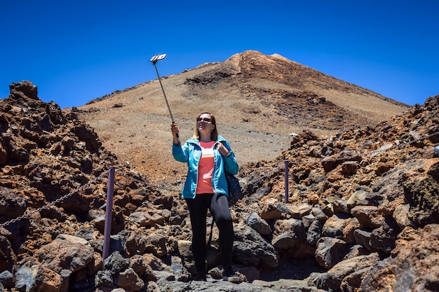 Une jeune femme voyageuse en lunettes de soleil fait du selfie avec vue sur le volcan Teide sur les îles Canaries de Tenerife Espagne