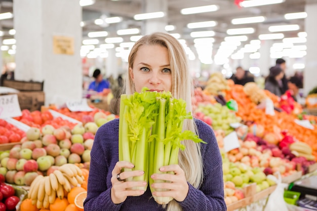 Jeune fille achète des légumes au marché