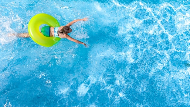 Jeune fille active dans la piscine Vue aérienne de dessus d'en haut, adolescent nage sur un anneau gonflable