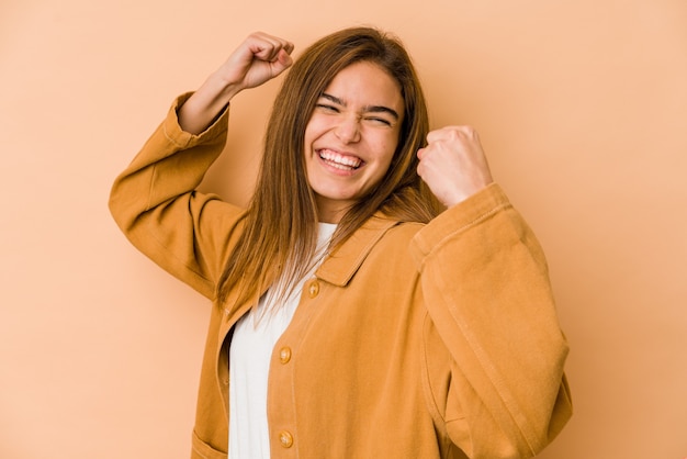 Jeune fille adolescente caucasienne maigre levant le poing après une victoire, concept gagnant.