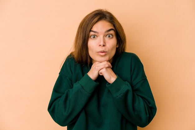 Jeune fille adolescente caucasienne maigre priant pour la chance, étonné et ouvrant la bouche à l'avant.