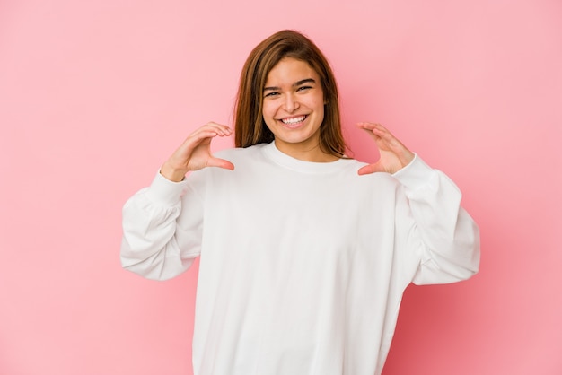 Jeune fille adolescente caucasienne maigre tenant quelque chose avec des paumes