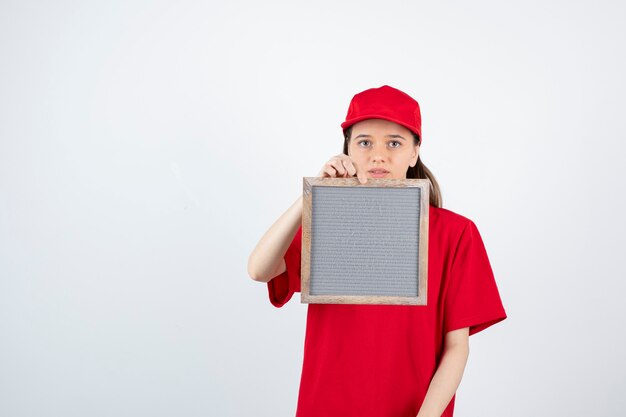 jeune fille adolescente en uniforme rouge debout et tenant le cadre