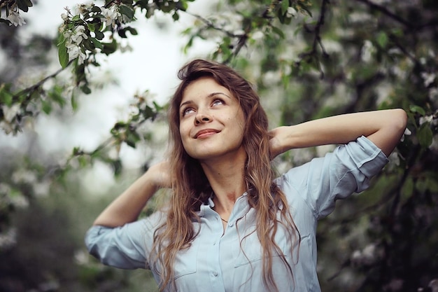 Une jeune fille adulte apprécie l'odeur des fleurs de printemps.