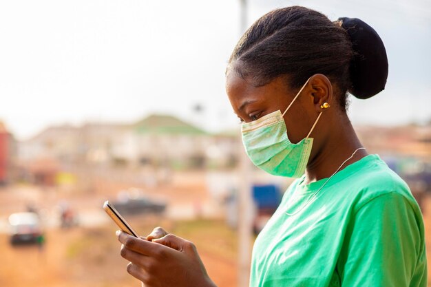 Jeune fille africaine noire portant un masque facial empêchant la propagation du virus corona. grippe portant un masque facial sensibilisant à l'utilisation d'un masque nasal