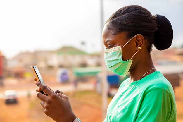 Jeune fille africaine noire portant un masque facial empêchant la propagation du virus corona. grippe portant un masque facial sensibilisant à l'utilisation d'un masque nasal