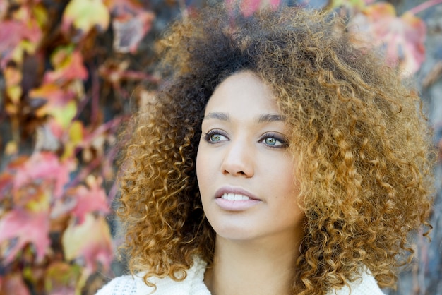 Photo jeune fille afro-américaine avec une coiffure afro et les yeux verts