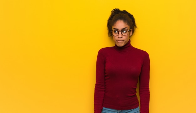 Jeune fille afro-américaine noire aux yeux bleus pense à une idée