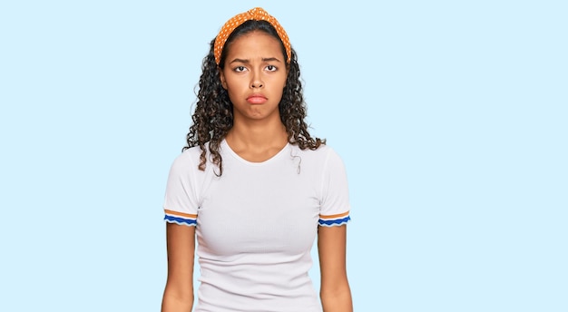 Jeune fille afro-américaine portant des vêtements décontractés déprimée et inquiète de la détresse, pleurant de colère et de peur. expression triste.