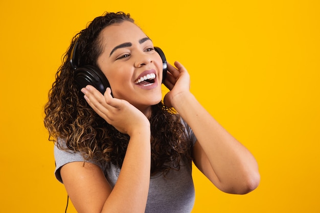 Jeune fille afro avec ses écouteurs écoutant de la musique. Fermer