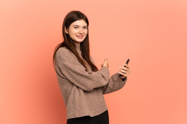 Jeune fille à l'aide de téléphone portable et pointant vers l'arrière