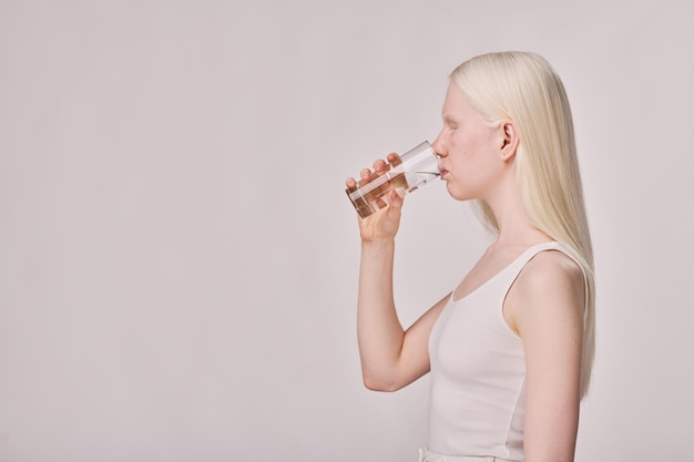 Jeune fille albinos buvant de l'eau