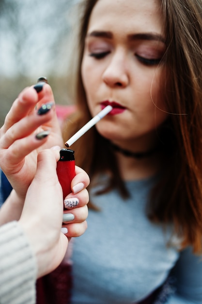 Jeune fille, allumer cigarette, dehors