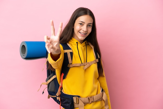 Jeune fille d'alpiniste avec un grand sac à dos d'isolement