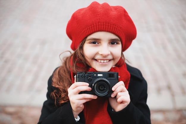 Jeune fille avec un appareil photo dans une rue de la ville. photo de haute qualité