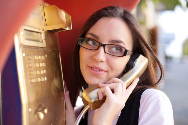 Photo jeune fille appel du téléphone de rue d'or